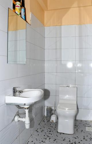 a bathroom with a sink and a toilet at Airport Bliss House in Kisumu