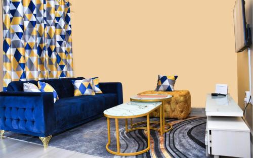 uma sala de estar com um sofá azul e uma mesa em Airport Bliss House em Kisumu