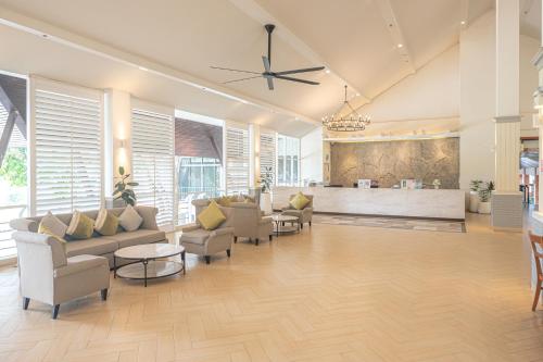 a living room with couches and chairs and a bar at Eco Hotel by Thammasat in Bang Lamung
