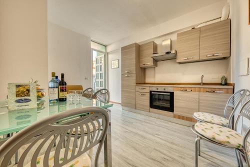 uma cozinha com uma mesa de vidro e cadeiras em Hotel Residence Charles em Rimini