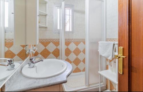 ein weißes Bad mit einem Waschbecken und einer Dusche in der Unterkunft Villa Elixabete in Ronda