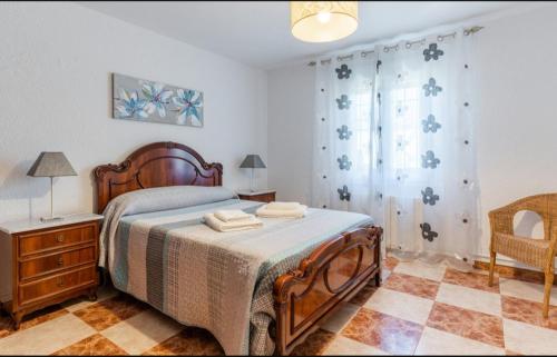 ein Schlafzimmer mit einem Bett, einer Kommode und einem Fenster in der Unterkunft Villa Elixabete in Ronda