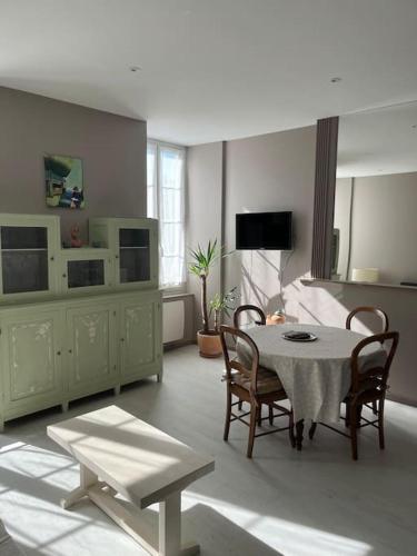 - un salon avec une table, des chaises et une télévision dans l'établissement Superbe appartement plein centre, à Millau