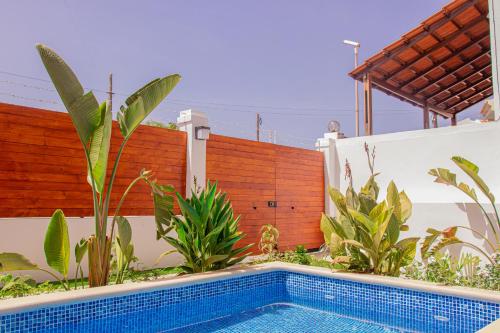 a swimming pool in front of a fence with plants at Villa PalMarina in Praia