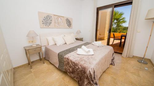 una camera da letto con un letto con scarpe bianche di Coto Real Naxos 202 a Manilva