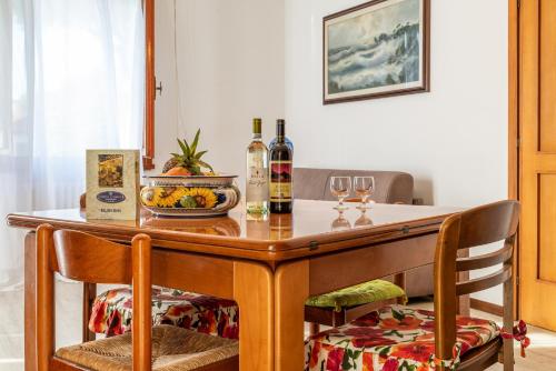 una mesa de madera con 2 sillas y botellas de vino en Hotel Residence Charles en Rímini