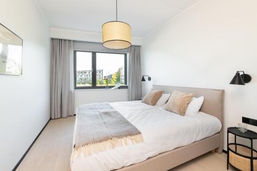 biała sypialnia z dużym łóżkiem i oknem w obiekcie Hilltop Apartments - Kiikri Residence City Centre w Tallinnie