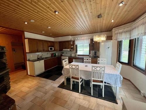 uma cozinha com mesa e cadeiras num quarto em Villa Grinberg em Mäntyharju