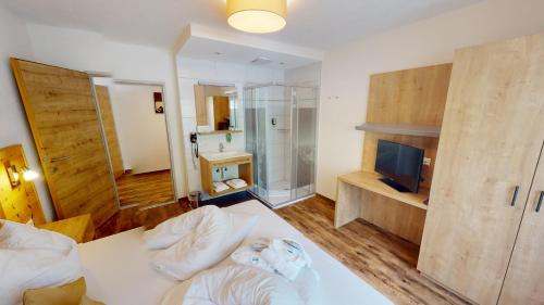 a bedroom with a bed and a television in a room at Pitztal Living Apartments in Jerzens