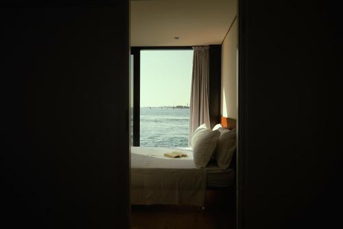 a bedroom with a bed and a window with the ocean at AQVA The Exclusive Water Loft in Venice in Venice