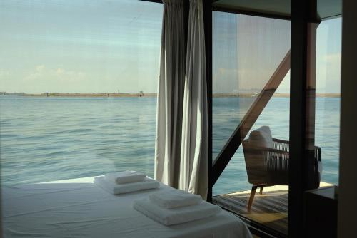 a room with a bed and a window with the water at AQVA The Exclusive Water Loft in Venice in Venice