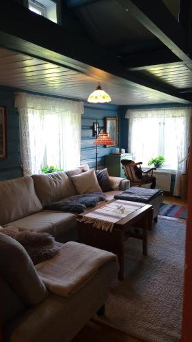 a living room with a couch and a table at Hallingstue by Hallstensgaard - Geilo in Geilo