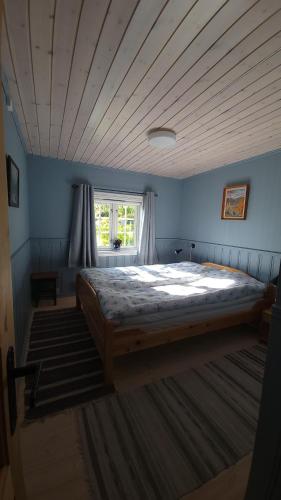 a bedroom with a large bed in a blue room at Hallingstue by Hallstensgaard - Geilo in Geilo