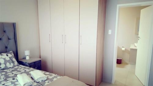 a bedroom with a bed and a white closet at Midrand Serene Escape in Midrand