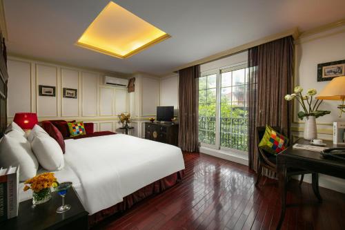 Schlafzimmer mit einem Bett, einem Schreibtisch und einem Fenster in der Unterkunft Hanoi Boutique Hotel & Spa in Hanoi