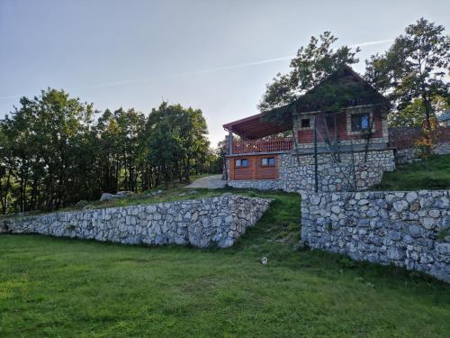 kamienna ściana i dom z kamiennym płotem w obiekcie Mountain Village House w mieście Cetynia