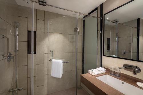 a bathroom with a glass shower and a sink at Uday Palace Navsari, a member of Radisson Individuals in Navsāri