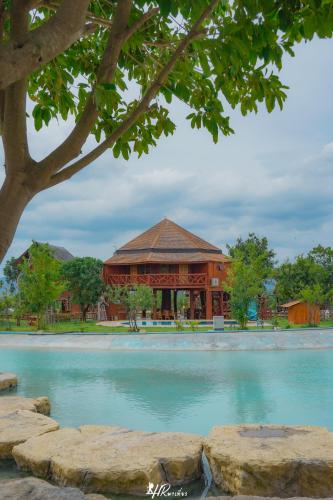 a large building in front of a pool of water at Tayama Farm Khaoyai in Nakhon Ratchasima