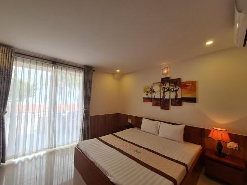 a bedroom with a bed and a large window at Hai Duong Intourco Resort, Vung Tau in Vung Tau
