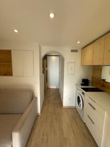 une cuisine avec un canapé et un lave-linge/sèche-linge dans l'établissement Appartement moderne Santa Giulia, à Porto-Vecchio