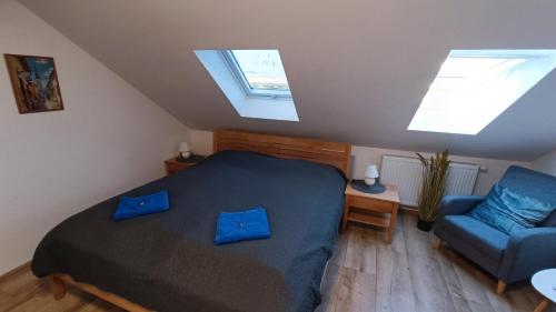 a bedroom with a bed and a chair and skylights at GUDU apartments in Košice
