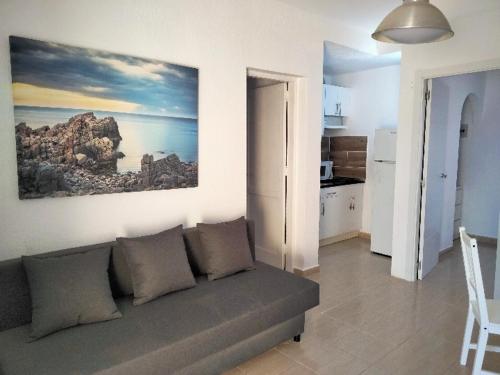 een woonkamer met een bank en een schilderij aan de muur bij Mirador de Sotavento apartment 8241 in Costa Calma