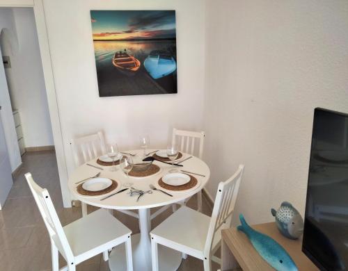 een eetkamer met een witte tafel en stoelen en een tv bij Mirador de Sotavento apartment 8241 in Costa Calma