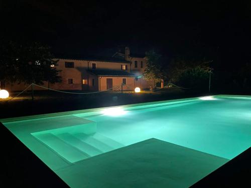 una piscina iluminada por la noche en Podere Le Volte degli Angeli en Spello