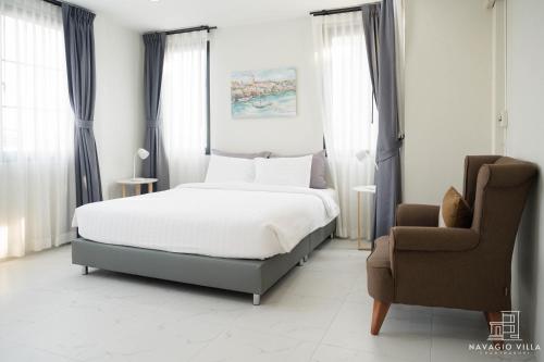a bedroom with a bed and a chair at Navagio Villa 