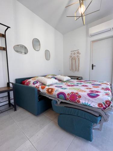 a bedroom with a bed with a colorful blanket at Studio neuf dans cadre idyllique proche nature in Aubais