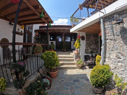 a patio of a house with potted plants at AgroSpito Traditional Guest House in Agros