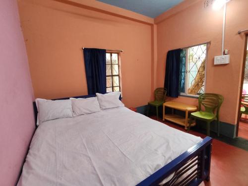1 dormitorio con 1 cama grande, mesa y ventanas en Atithi Nibas Home stay, 