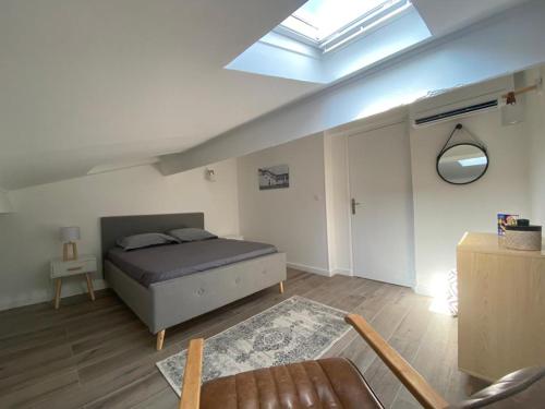 una camera con letto, divano e lucernario di appartement T2 au centre ville de Sanary sur mer a Sanary-sur-Mer