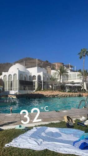 a swimming pool in front of a large house at Lovely studio Nerja ground floor in Nerja