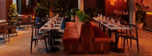 une rangée de tables avec des sièges rouges dans un restaurant dans l'établissement Kube Hotel Paris, à Paris