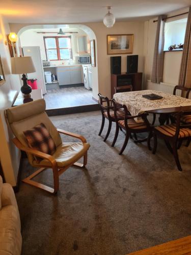 a living room with a dining room table and chairs at Brown Cow Apartment in Dalton in Furness