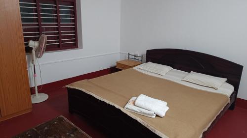 a bedroom with a bed with towels on it at O2 estate stay in Virajpet