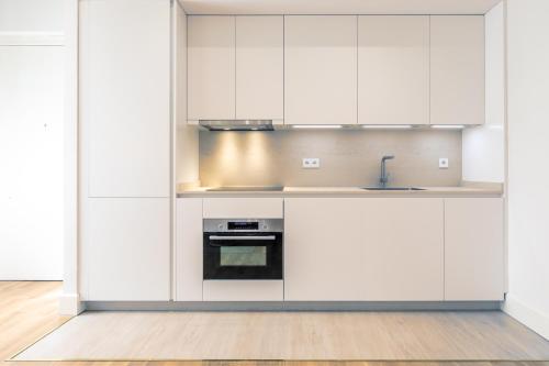 a kitchen with white cabinets and a sink at Magno Apartments Casa del Correo Mayor II in Seville