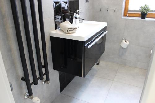 La salle de bains est pourvue d'un lavabo blanc et d'un miroir. dans l'établissement Apartament Biały na osiedlu "Apartamenty pod Śnieżką", à Karpacz