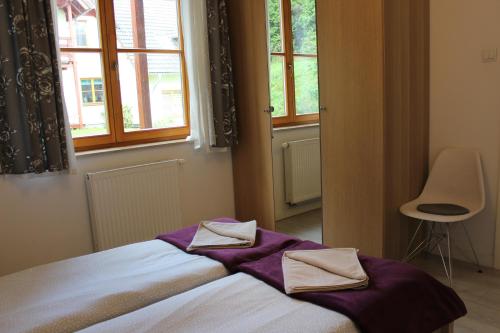 - une chambre avec un lit, une chaise et des fenêtres dans l'établissement Apartament Biały na osiedlu "Apartamenty pod Śnieżką", à Karpacz