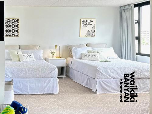 two beds in a bedroom with white walls at Stunning 1BD a block away to Waikiki Beach Free Parking in Honolulu