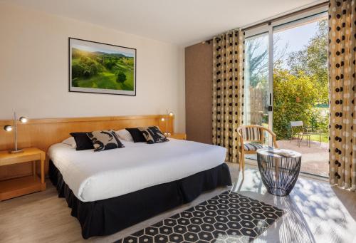 a hotel room with a bed and a large window at Golf Domaine Du Val De Sorne in Vernantois