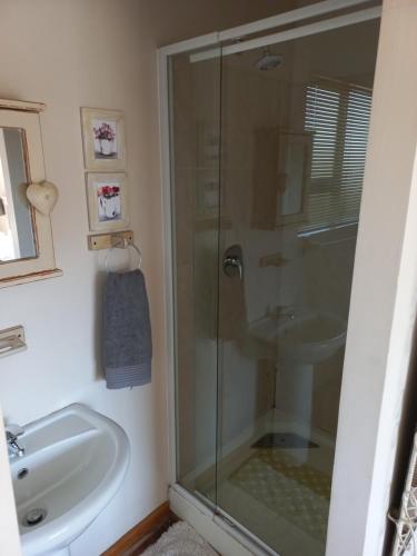 a bathroom with a glass shower and a sink at Twogether self catering in Clarens