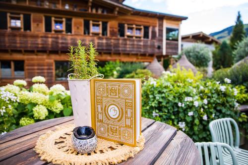 a book sitting on top of a table with a plant at Alpin Juwel - Bio und Lifestylehotel in Saalbach Hinterglemm