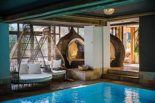 a resort with a swing and a swimming pool at Alpin Juwel - Bio und Lifestylehotel in Saalbach Hinterglemm