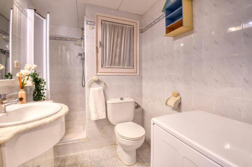 biała łazienka z toaletą i umywalką w obiekcie Bosmar 10F w mieście Pals