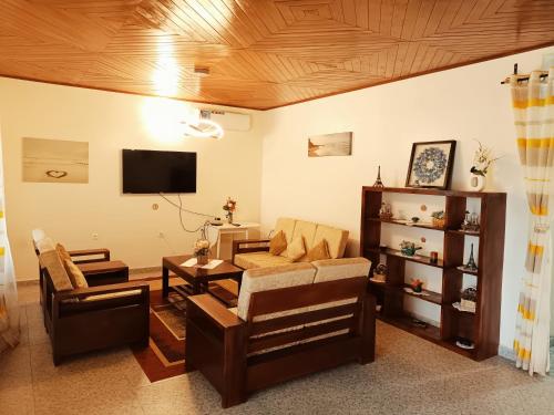 - un salon avec un canapé et une télévision dans l'établissement RESIDENCE DORANA, à Kribi