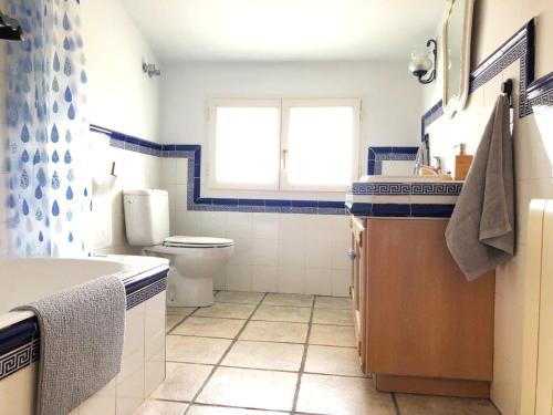 a bathroom with a toilet and a sink and a window at El rincón de Matilde con jardín By Kabia Gestión in Barrika