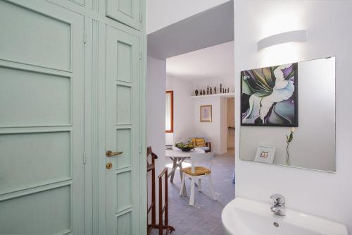 een badkamer met een deur, een wastafel en een tafel bij Yellow Suite sul Lungomare di Recco by Wonderful Italy in Recco