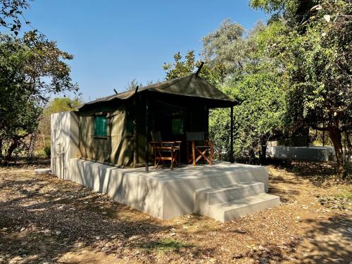 a small tent with a table and chairs in it at Msandile River Lodge in Kakumbi